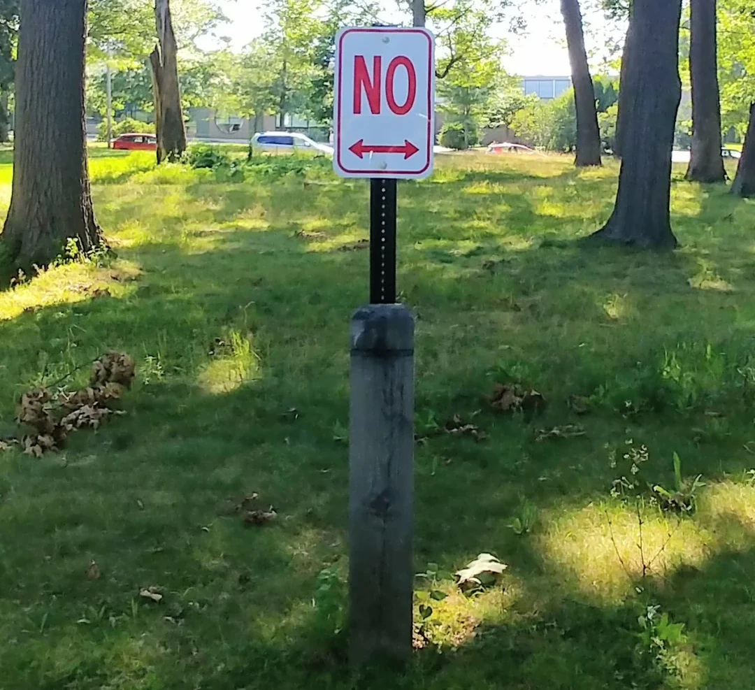 A white road sign with &ldquo;NO&rdquo; in large red letters and an arrow pointing left and right